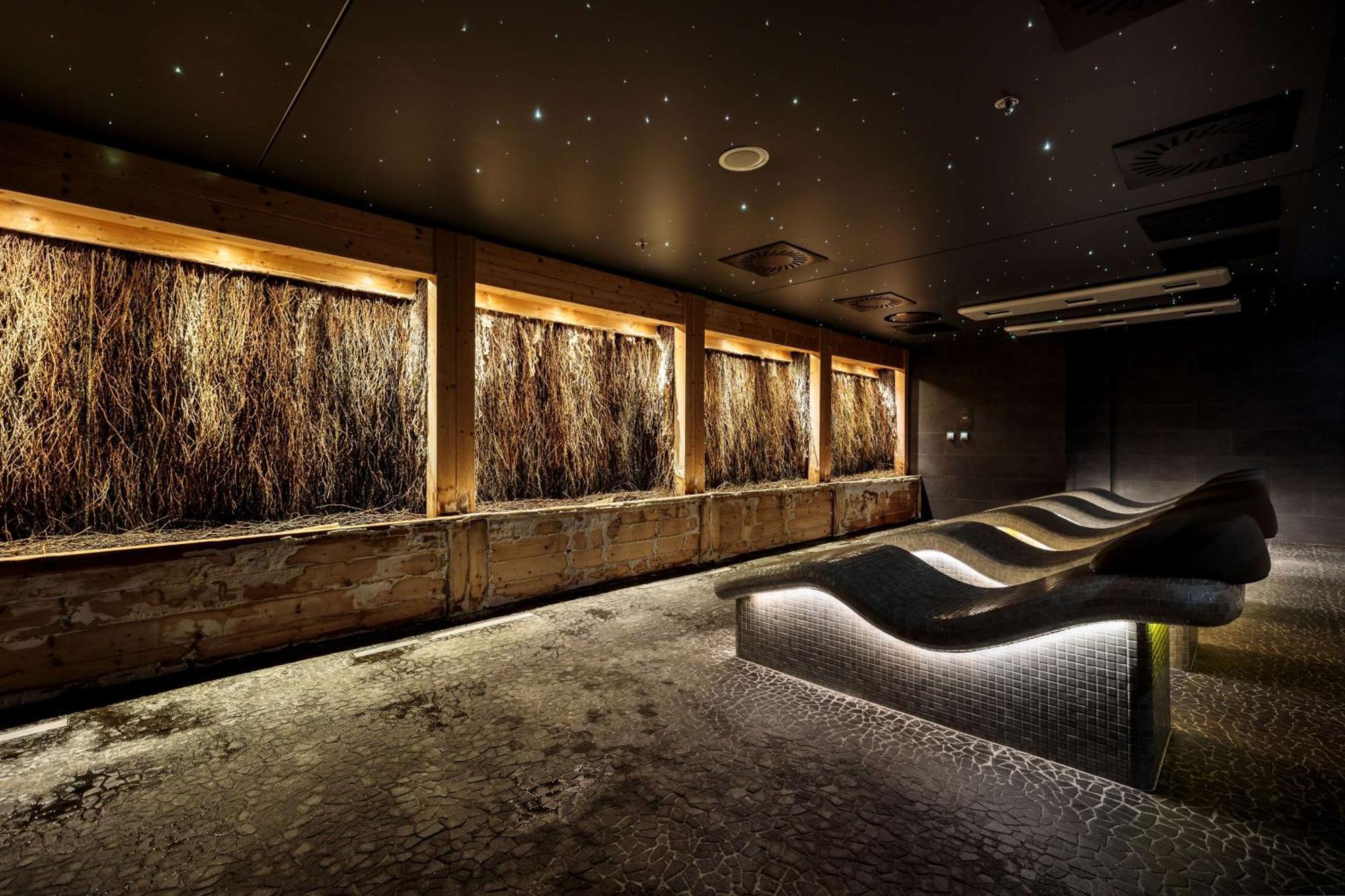 Radisson Blu Resort Swinoujscie Bagian luar foto The photo depicts a modern, serene spa or relaxation space. It features several wooden-framed windows that showcase natural elements, possibly dried grass or plants, creating a calming atmosphere. The walls are dark, and the ceiling may have lights r